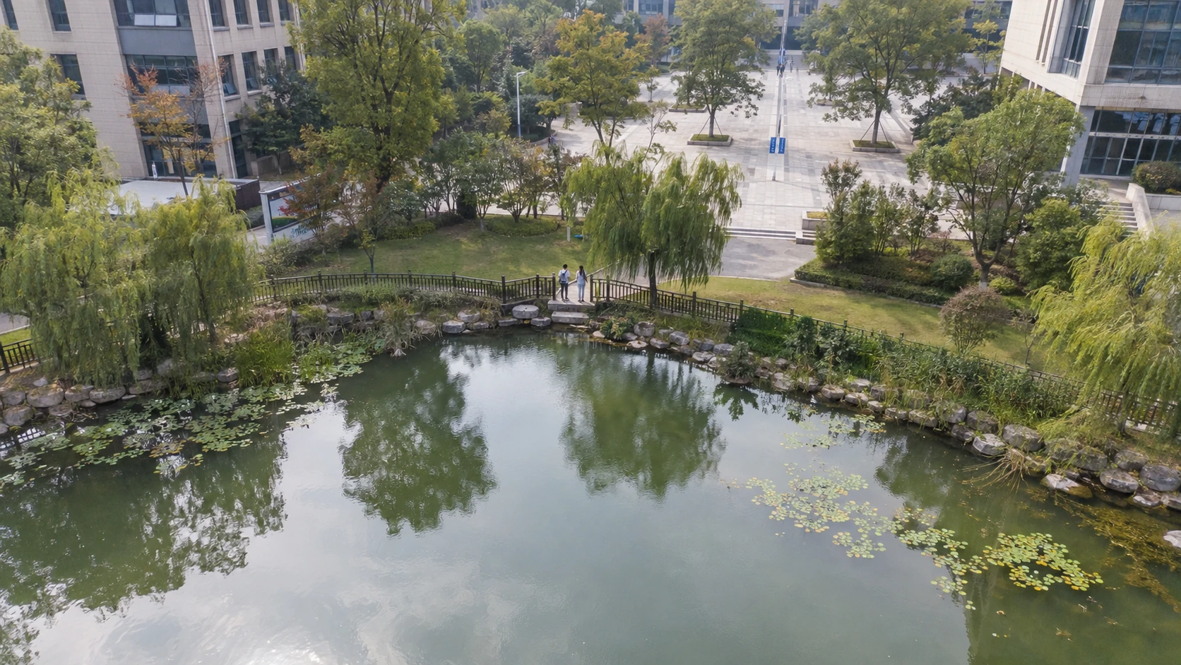 校园临水危险区域活动巡查:独立无人机航拍场景与红色目标标注示意